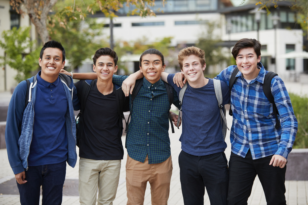 portrait of male high school students outside college buildings